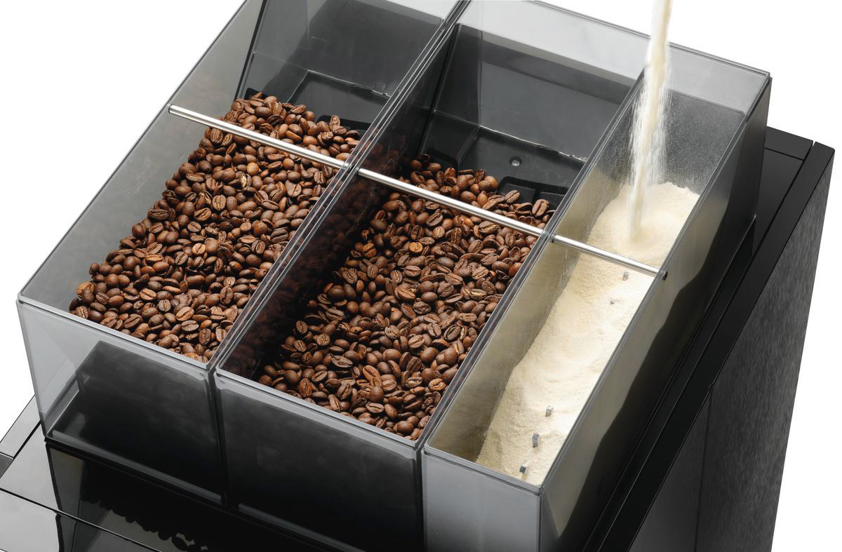 Kaffeebohnen und Pulver in einem Behälter. Pulver wird in den Behälter gegossen. Schwarze Maschinenbasis.