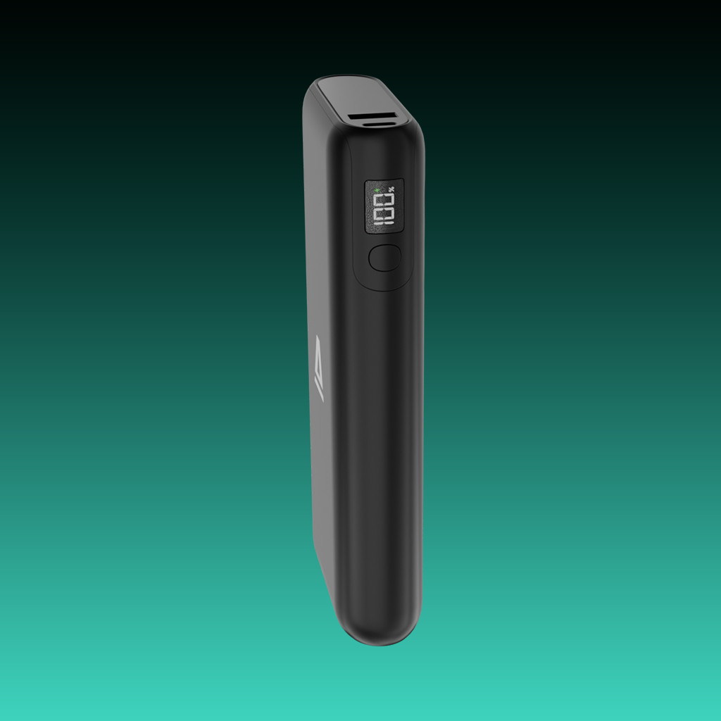 Egy fekete power bank 100%-os töltöttséget mutat. Zöldeskék háttér előtt van.