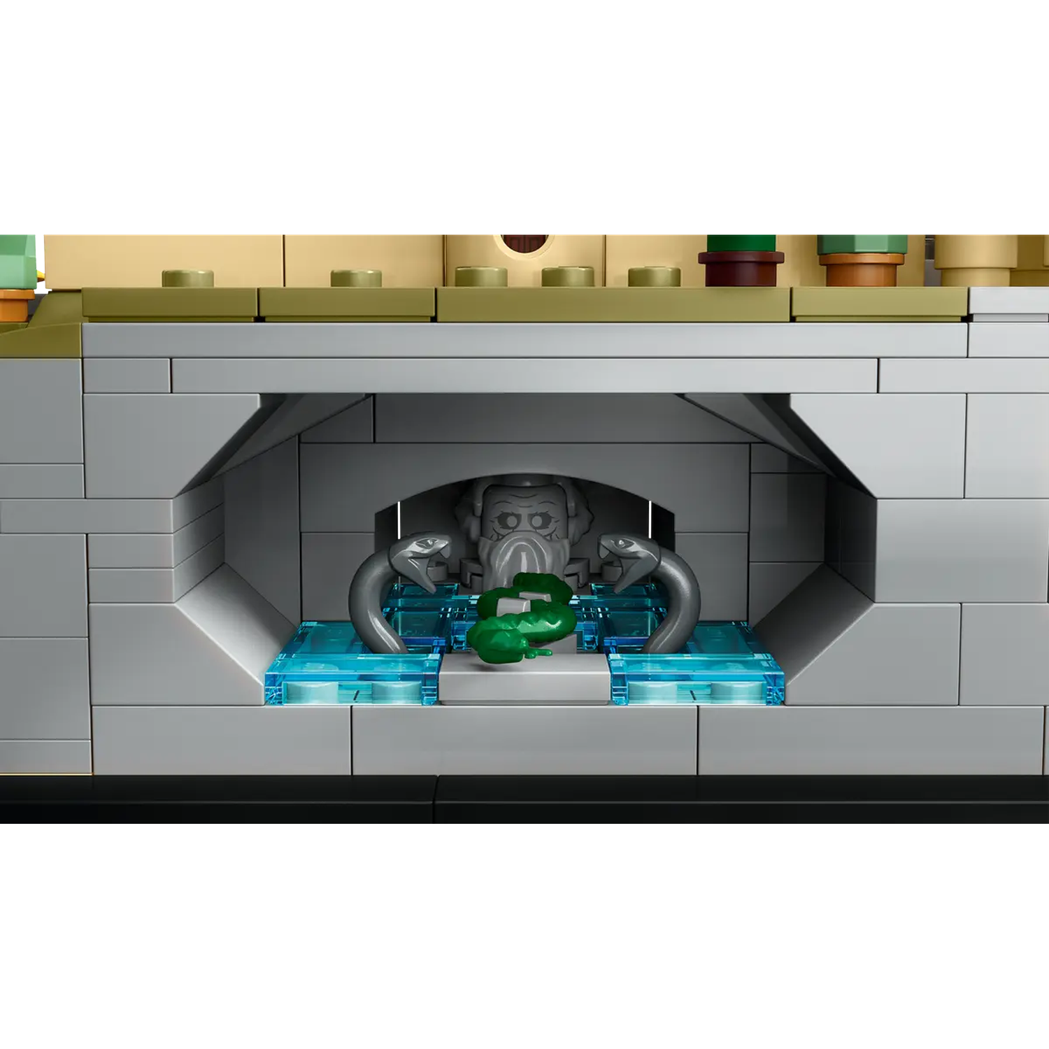 A Lego scene features a stone structure with a gray bust, two snake figures, and a green object. Blue transparent blocks are present.
