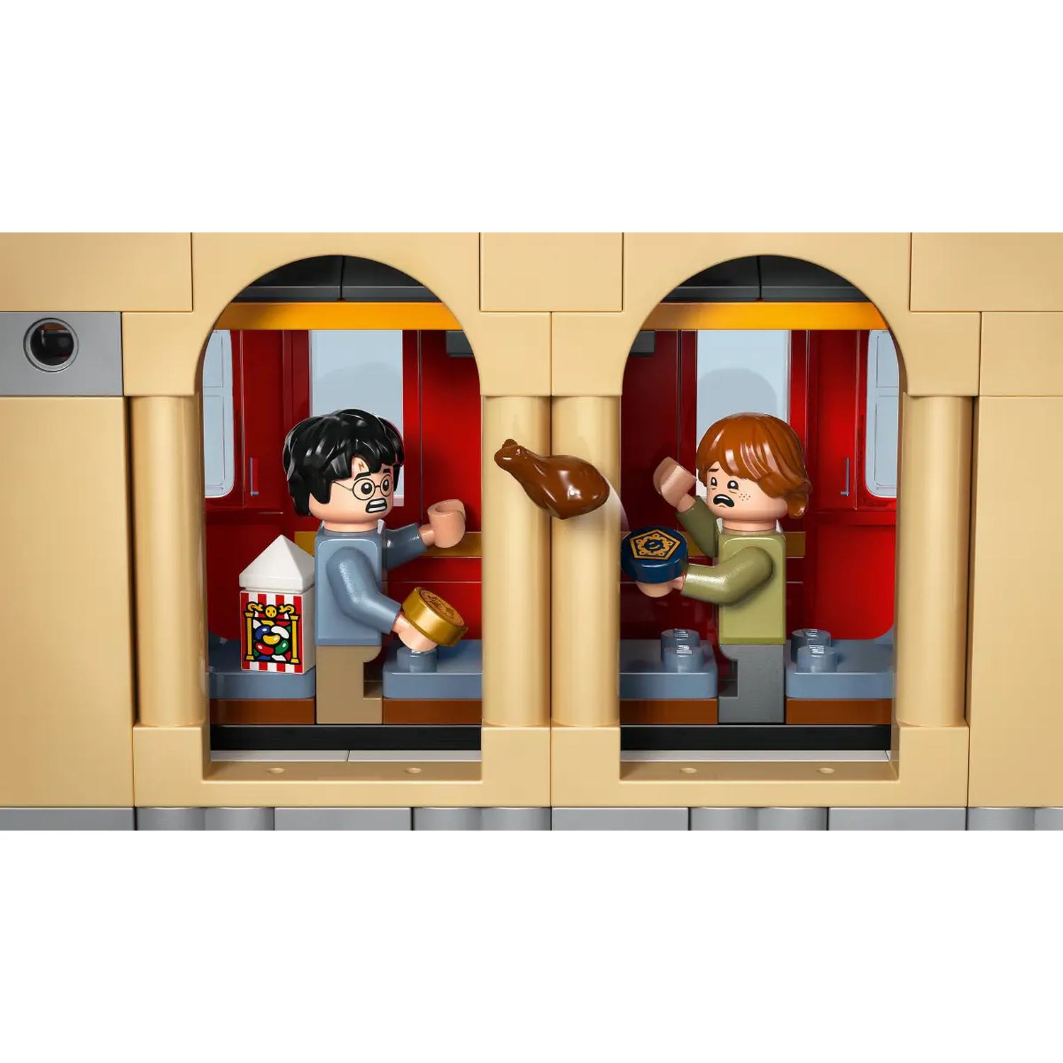 Lego Harry Potter set. Harry and Ron in train. Harry holds a gold coin and popcorn. Ron looks at a flying chicken.