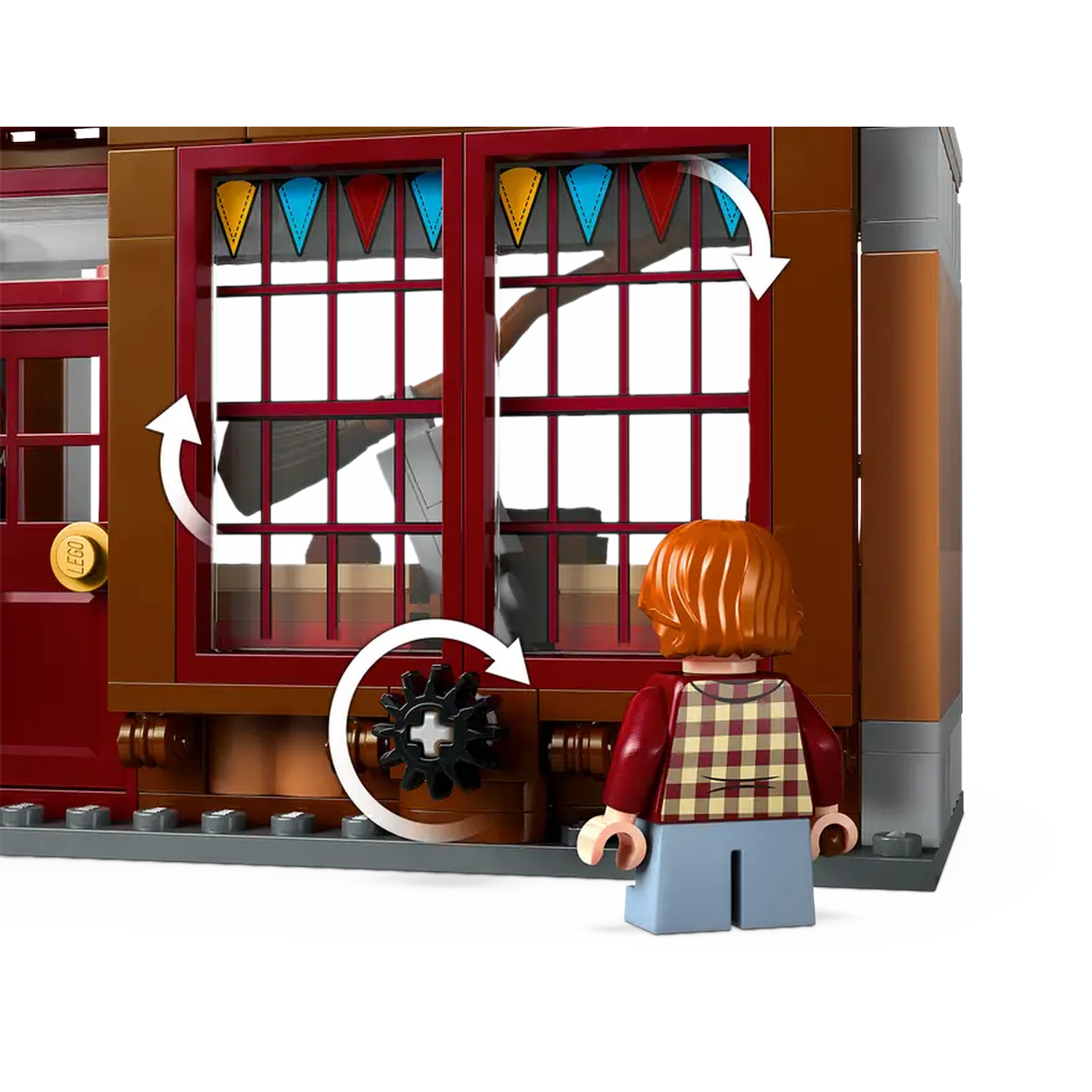 A Lego figure stands before a brown building with red window frames. Windows are decorated with colorful triangle flags.
