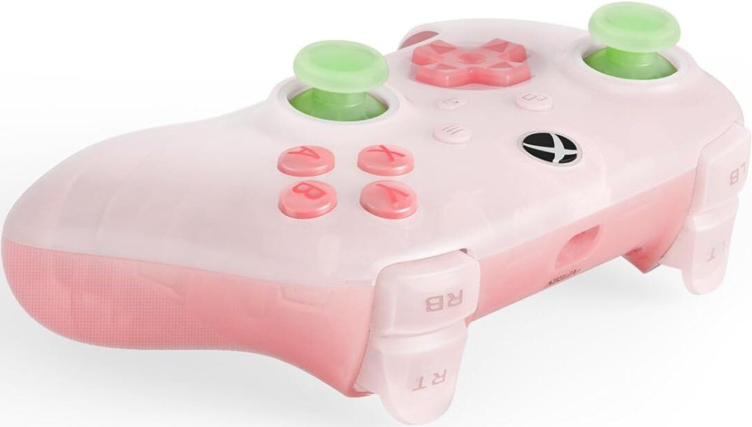 Różowy kontroler Xbox z zielonymi gałkami i różowymi przyciskami. Design jest w jasnoróżowym kolorze na białym tle.