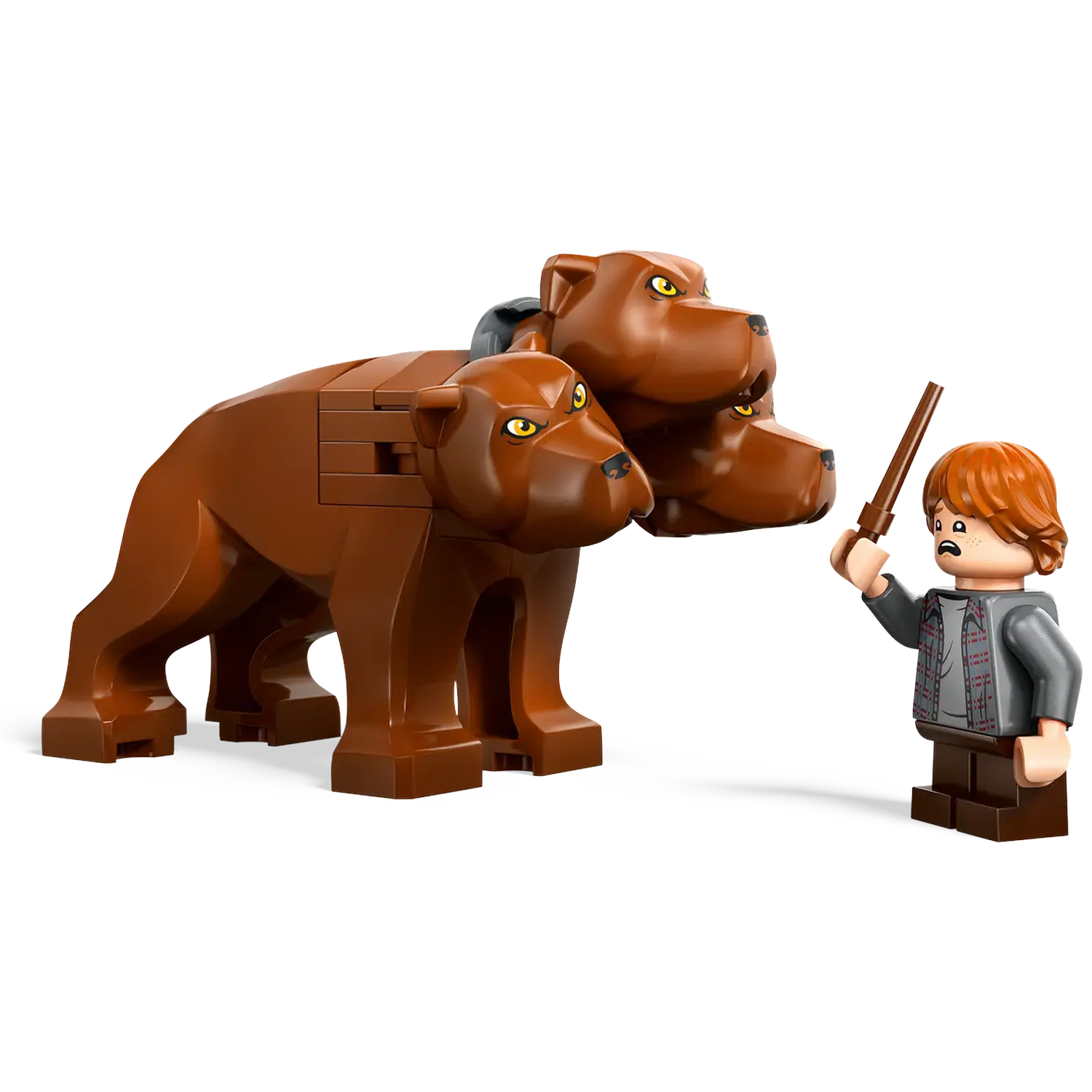 A Lego figure of Ron Weasley with a wand faces a brown, three-headed dog. The dog stands on all fours.