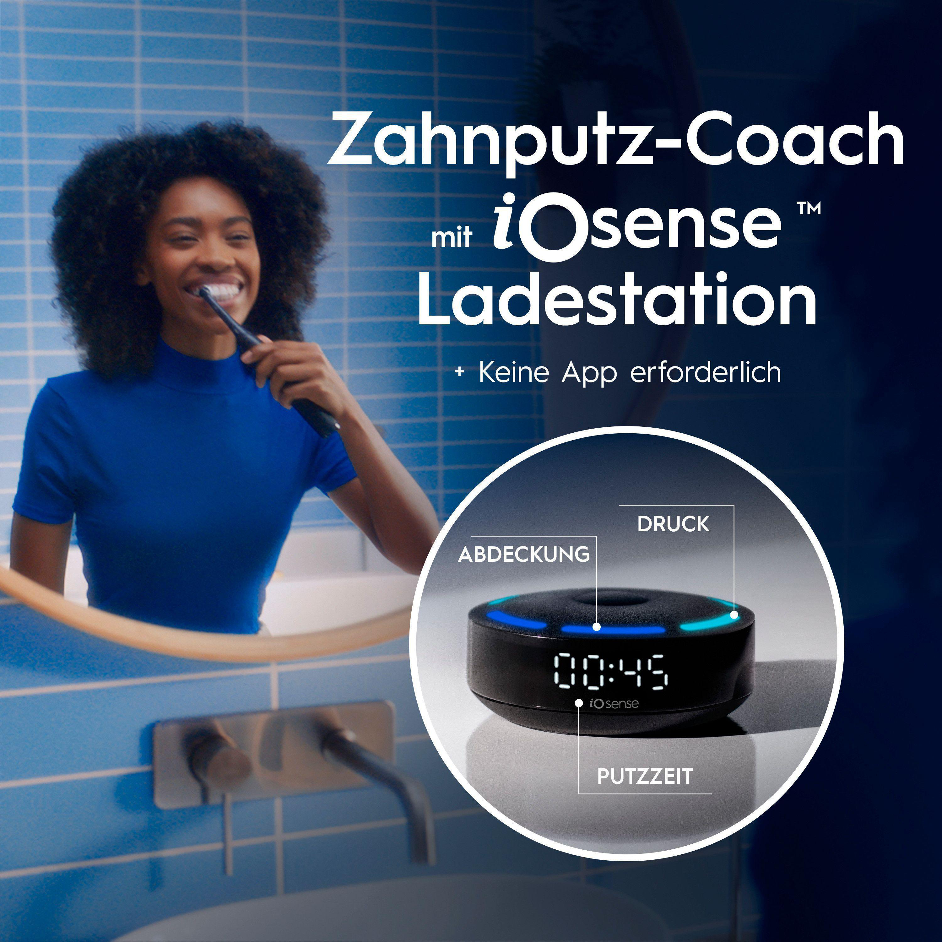 Eine Frau putzt sich die Zähne mit einer schwarzen Zahnbürste. Eine Ladestation zeigt die Zeit. Text: Zahnputz-Coach mit iOsense Ladestation.
