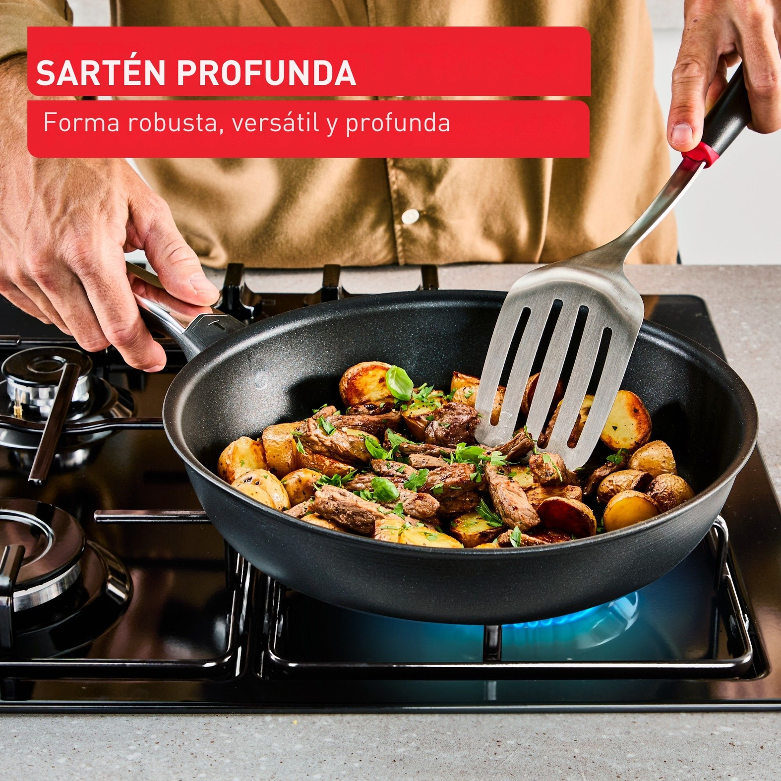 Una sartén en una estufa con comida que se revuelve. La sartén es negra, está llena de comida y se usa una espátula.