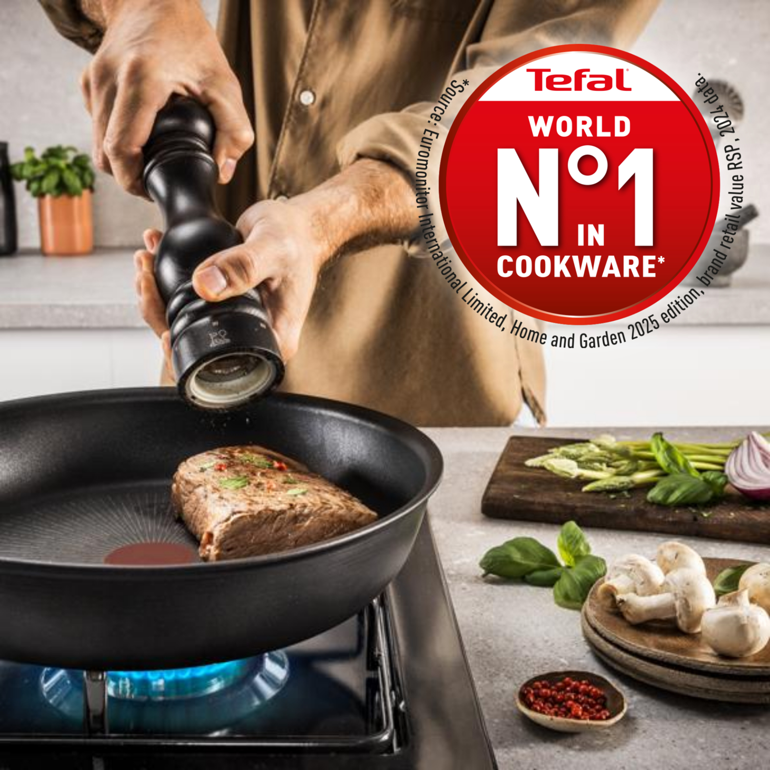 Una persona muele pimienta sobre un bistec en una sartén. También se ven verduras y el logo de Tefal.