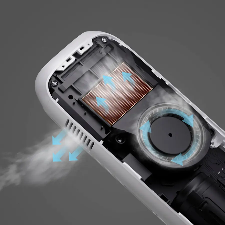 Egy nyitott eszköz ventilátorral és hűtőbordával. A nyilak a légáramlást mutatják. Egy kis gőz távozik. A készülék fehér és fekete.