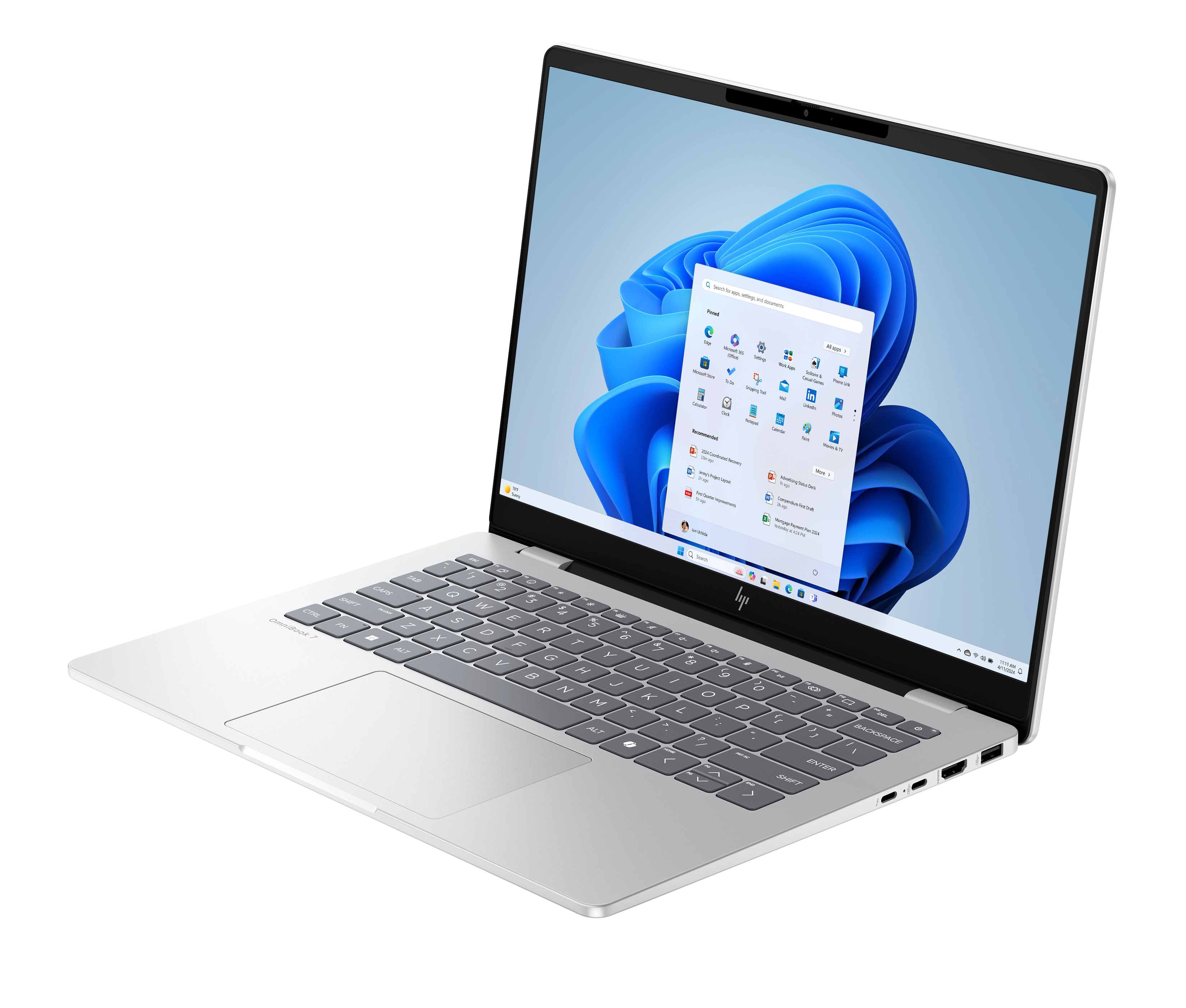 Srebrny laptop z interfejsem Windows 11, otwarty. Widoczna klawiatura. Ekran wyświetla aplikacje i niebieskie kształty.