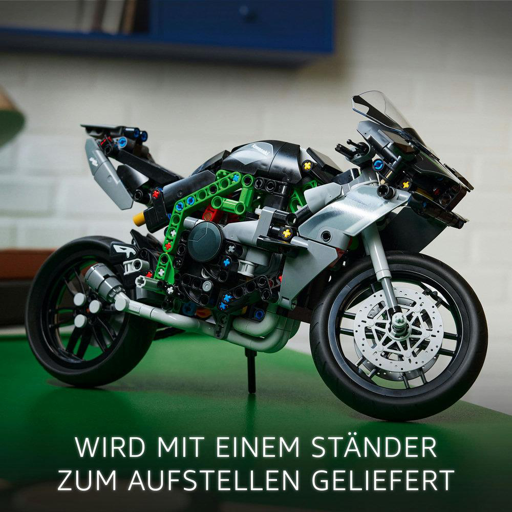 Detailliertes Motorradmodell aus Blöcken. Es hat schwarze, grüne und silberne Komponenten. Vorderrad und Scheibenbremsen sind sichtbar.