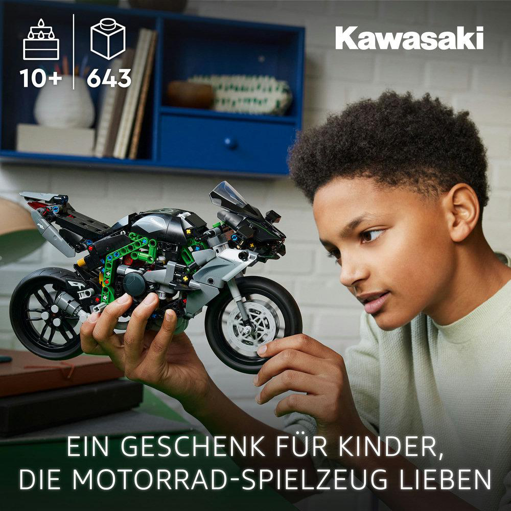 Ein Junge betrachtet ein Spielzeugmotorrad mit der Aufschrift Kawasaki. Das Set ist für Kinder ab 10 Jahren und hat 643 Teile. Text: 'Ein Geschenk für Kinder, die Motorräder lieben'.