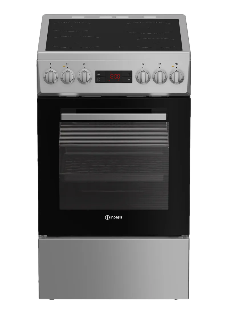 Un four électrique Indesit argenté avec une porte en verre noire. Il possède une horloge numérique et quatre zones de cuisson.