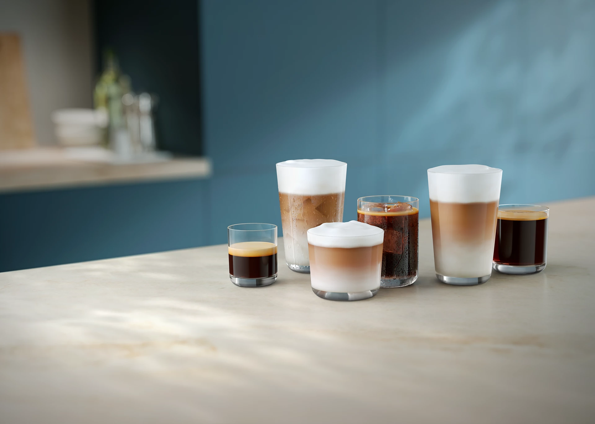 Mehrere Kaffeegetränke in Gläsern auf einem Tisch. Enthält Espresso, Latte Macchiato und Eiskaffee, vor blauem Hintergrund.