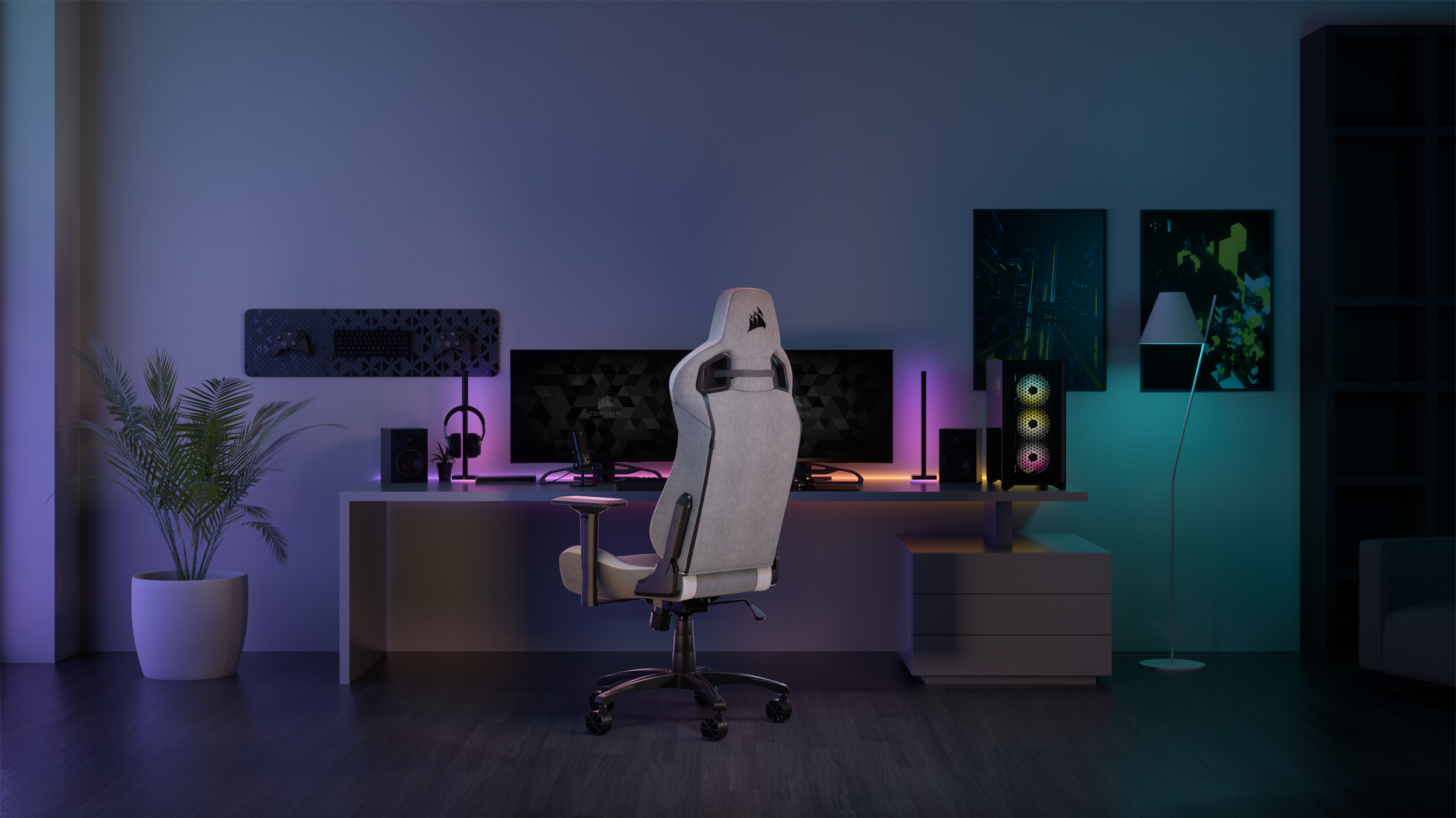 Gaming-Setup mit Stuhl, zwei Monitoren, PC, Lautsprechern und Pflanze. Umgebungslicht in dunklem Raum.