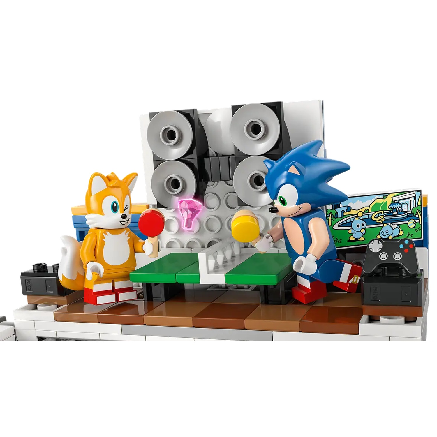 Lego Sonic en Tails spelen tafeltennis. Een spelconsole en een scherm met een spelscène zijn zichtbaar op de achtergrond.