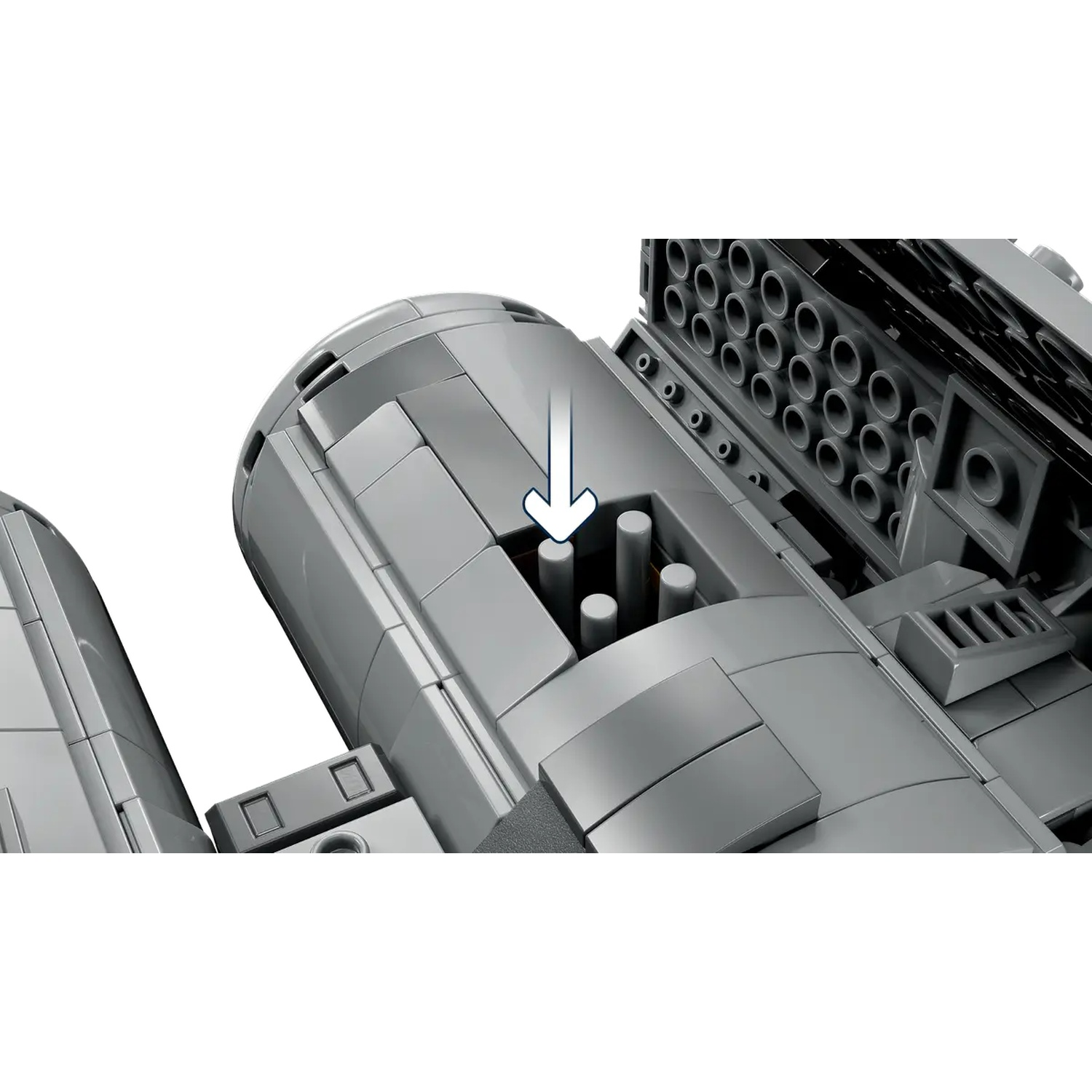 A close-up of a gray LEGO model. A white arrow points to the inside of the model. There are several round holes visible.