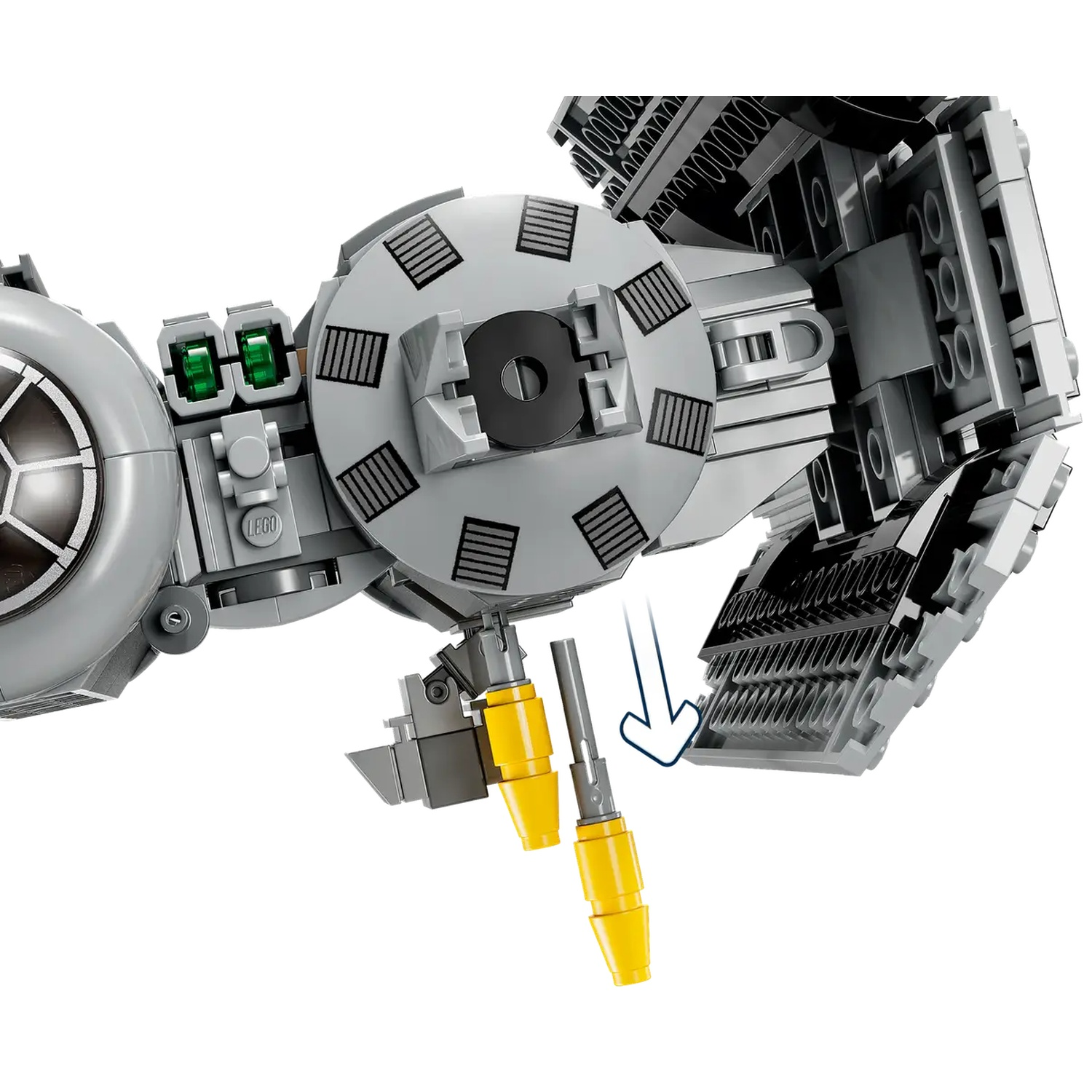 A Lego model of a spaceship is shown. The gray and black spaceship has yellow details and an arrow indicating where a piece fits.