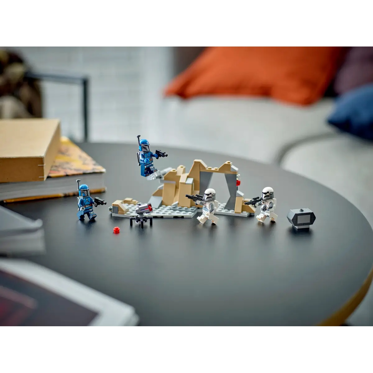 Lego Star Wars set on a table. Several figures and a small structure are arranged. A couch is visible in the background.