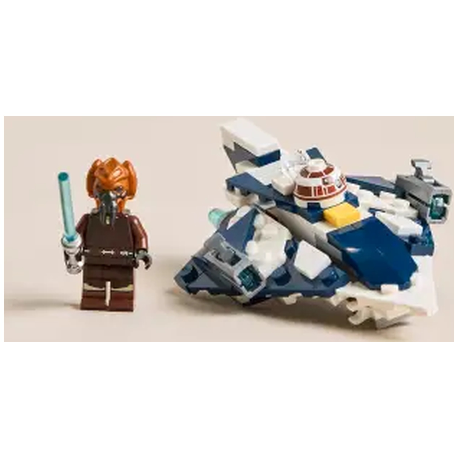 A Lego figure holding a blue lightsaber stands next to a Lego spaceship. The ship is blue, white, and gray.