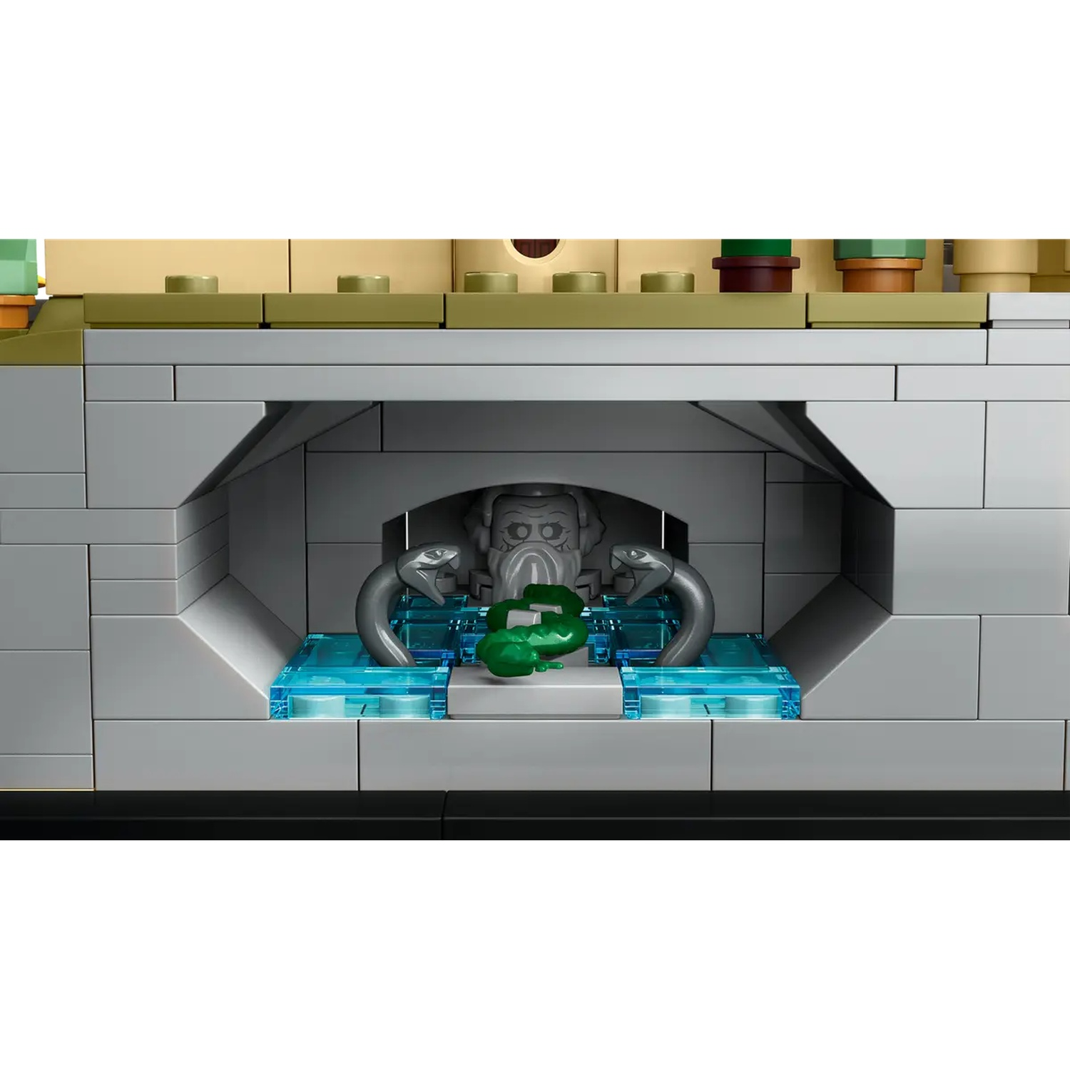 Een Lego-bouw met een stenen structuur met een slangenkop en groene objecten. De achtergrond heeft groene en bruine blokken.