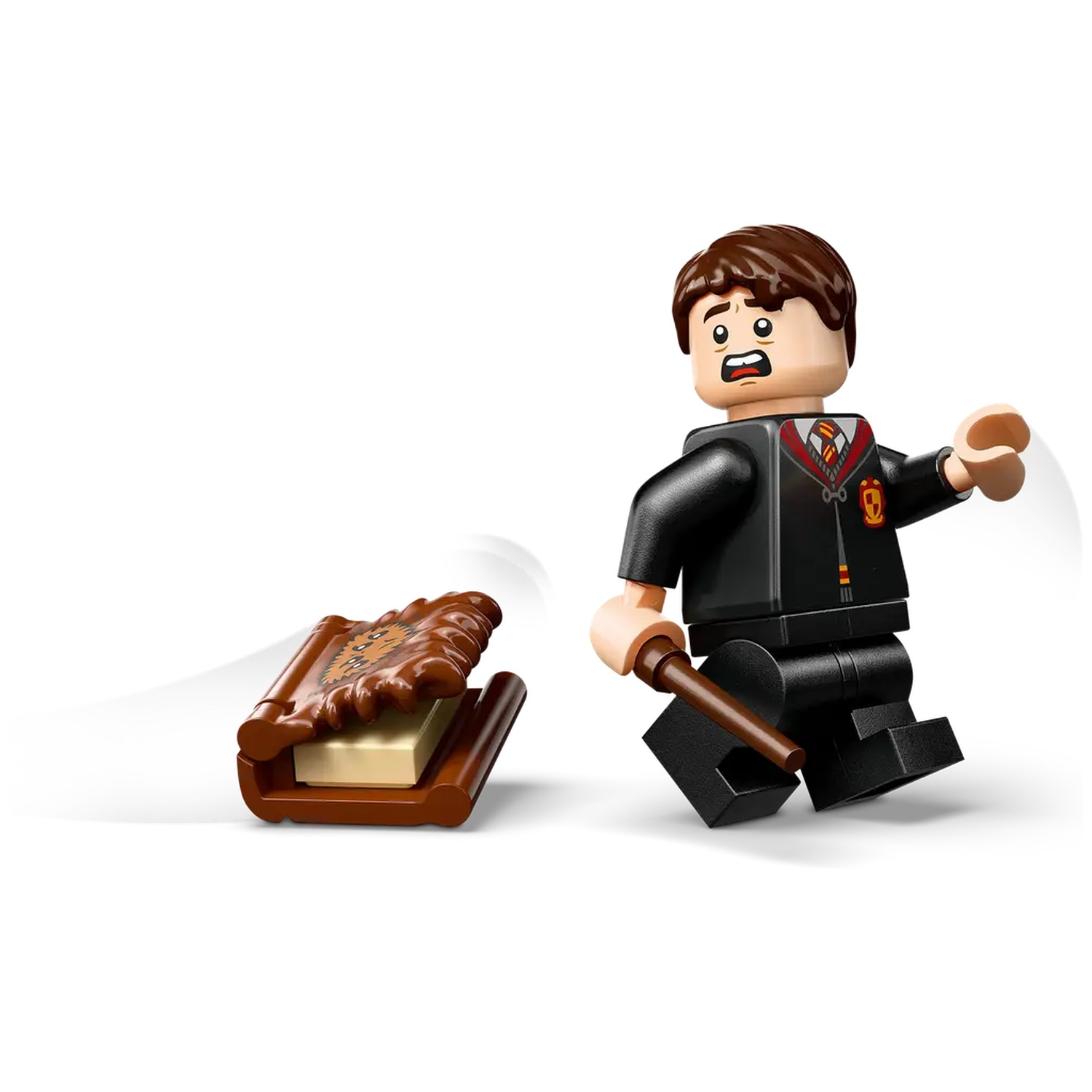 A Lego Harry Potter figure with brown hair, a black robe, and a wand. A brown book is on the left. The figure looks surprised.