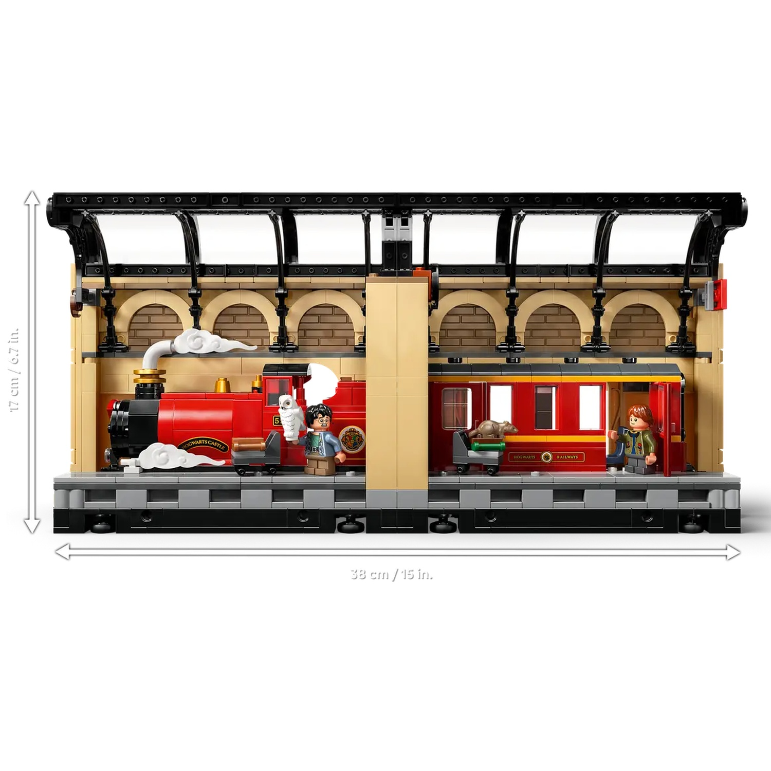 A Lego train set depicts a red train with figures on a platform. The station has a roof and arched brick walls.