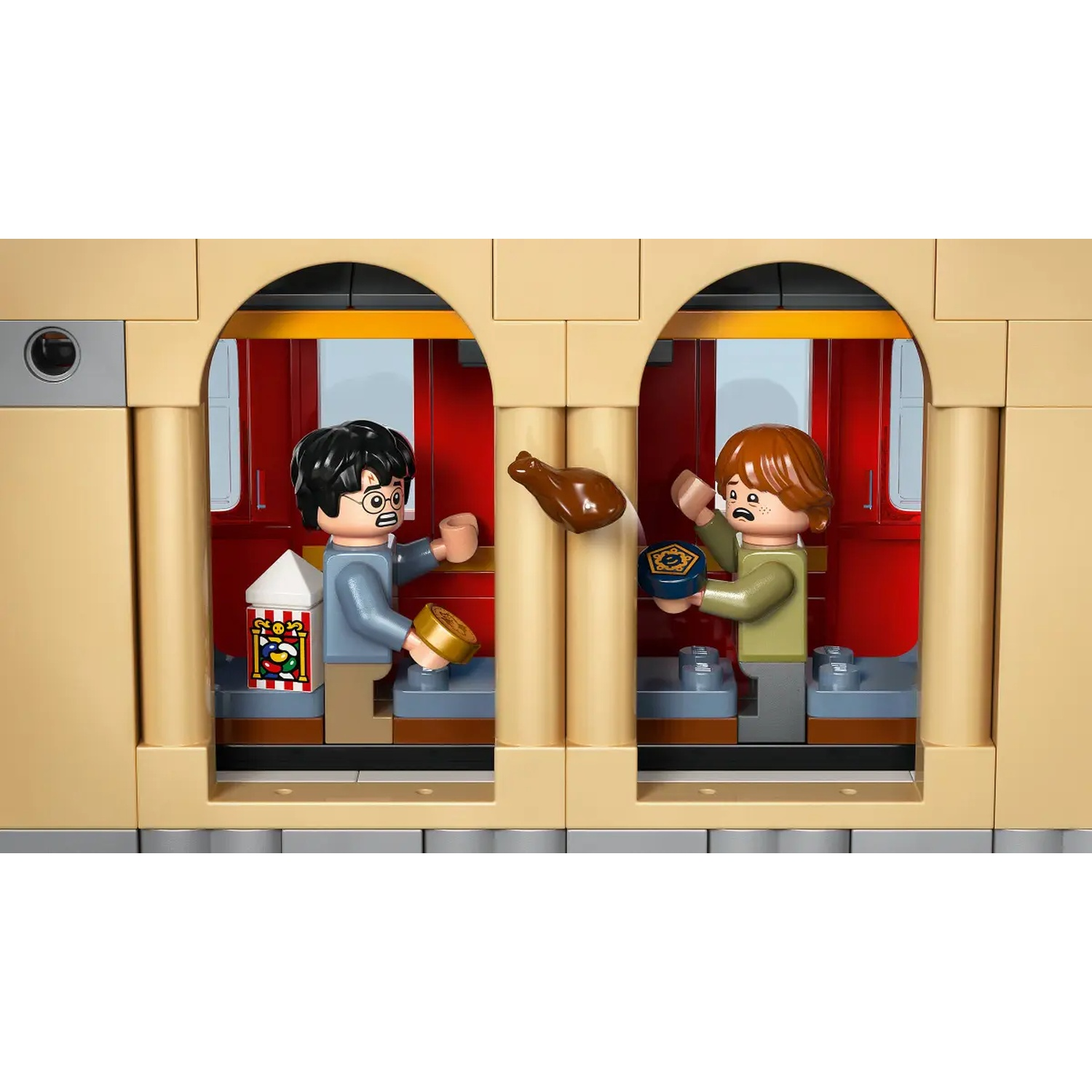 Lego scene with Harry and Ron. Harry holds a gold coin and popcorn. Ron holds a blue plate. A brown piece of food flies.
