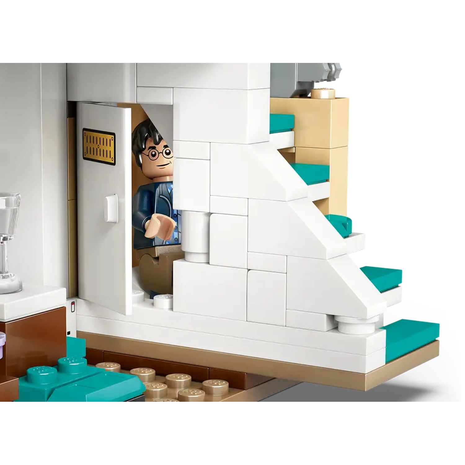 Lego set with a Harry Potter figure in a doorway. White stairs with teal steps and a brown counter are visible.