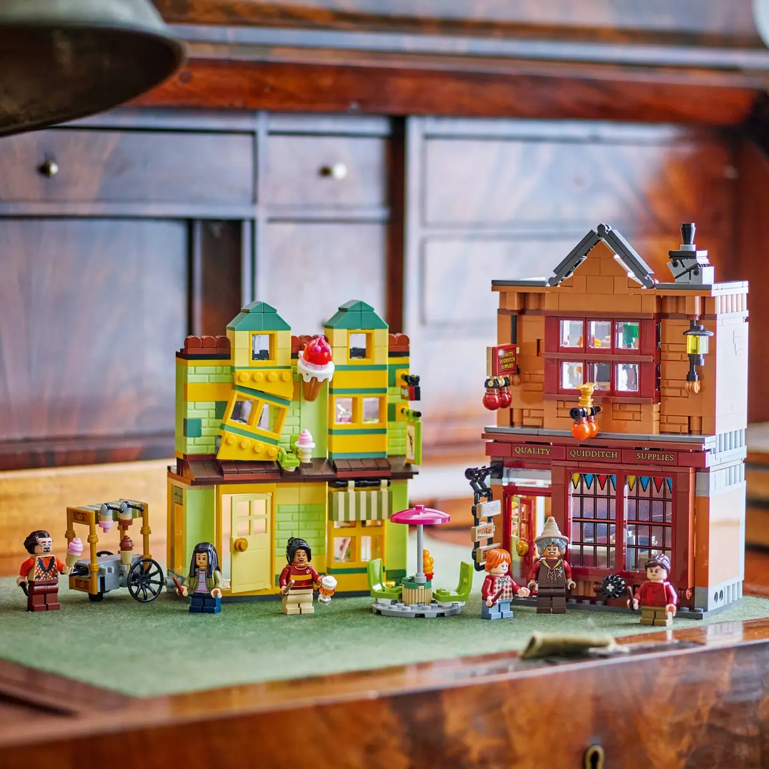Lego set of two buildings and mini figures. One is a shop, the other an ice cream parlor. Figures are standing around.