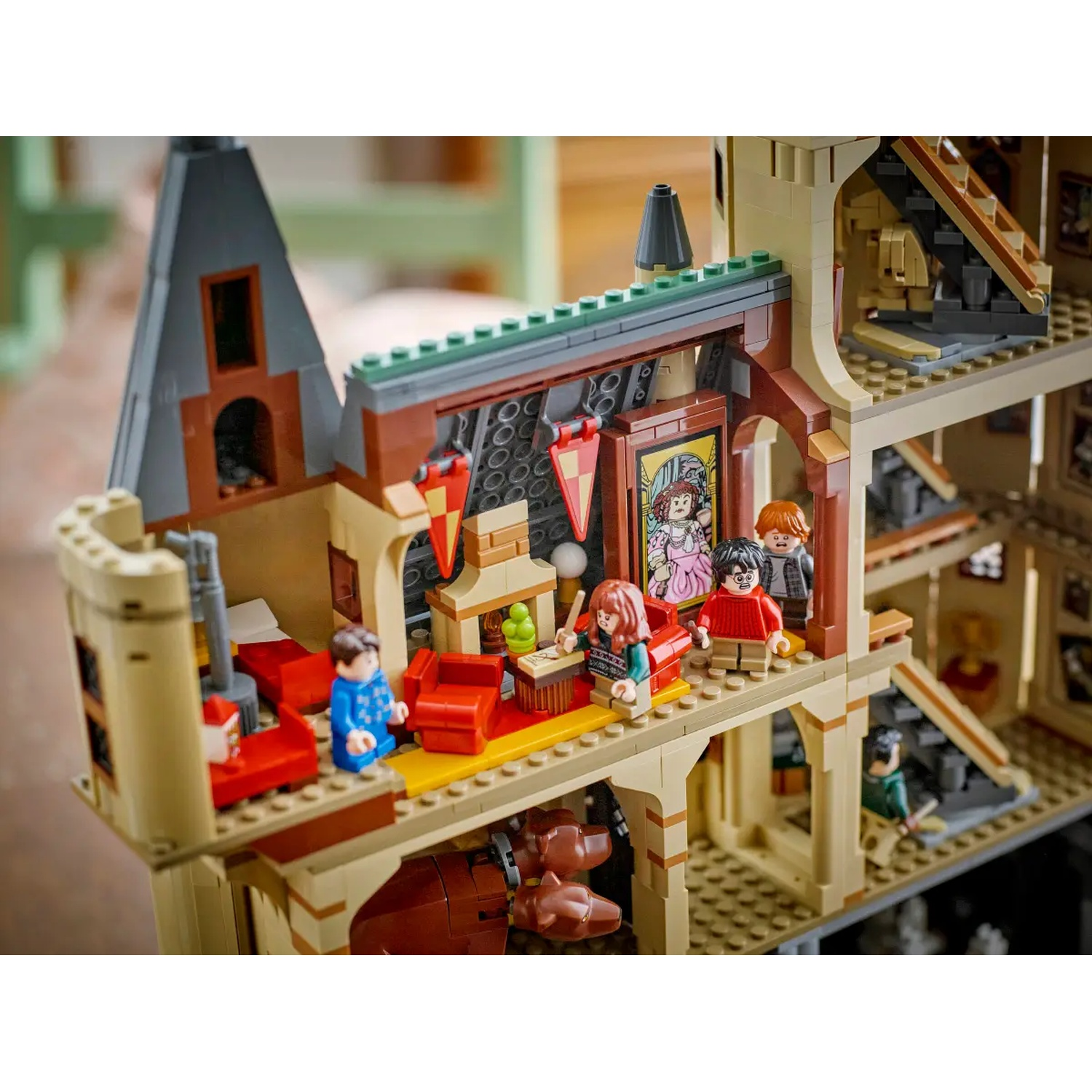 Lego-set van het interieur van het kasteel van Hogwarts, er zijn figuren van Harry Potter-personages aanwezig. Rode stoelen en diverse kamers zijn zichtbaar.