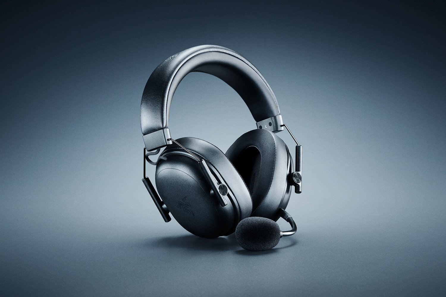 Cuffie da gaming Razer nere con microfono su sfondo grigio scuro. Le cuffie sono centrate e leggermente angolate.