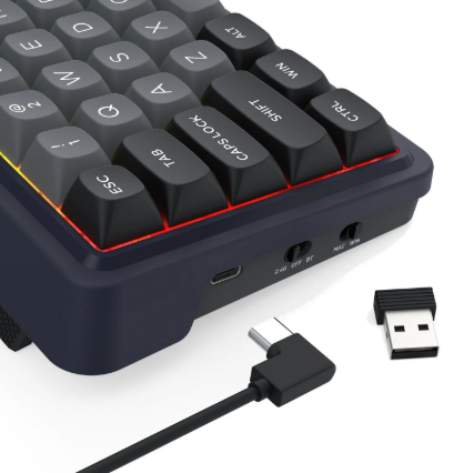 Zbliżenie ciemnoszarej klawiatury z czarnymi klawiszami. Widoczny jest kabel USB-C i odbiornik USB.