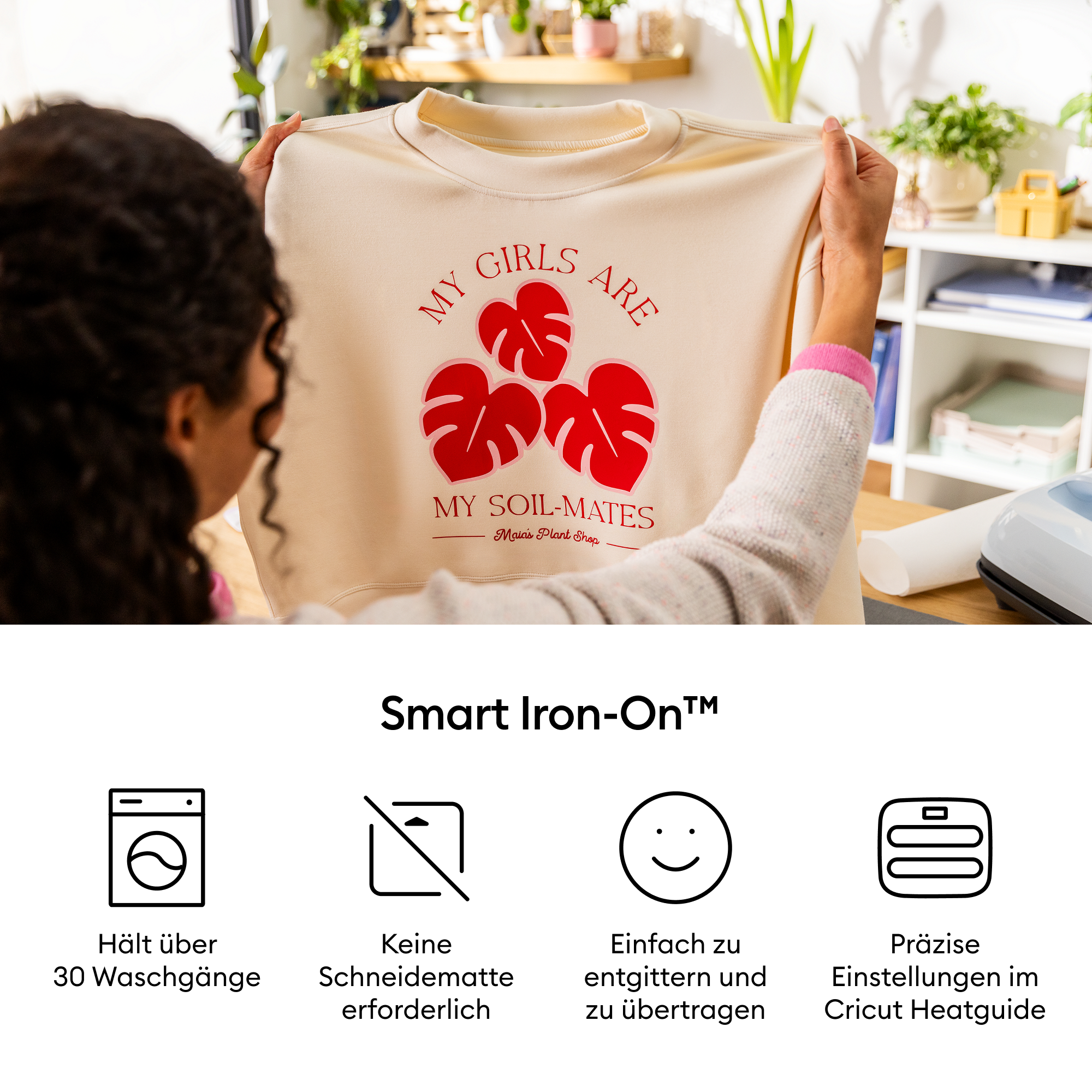 Eine Frau hält einen beigen Pullover mit rotem Text und Blattdesigns. Darunter erklären Symbole die Smart-Iron-On-Funktionen.