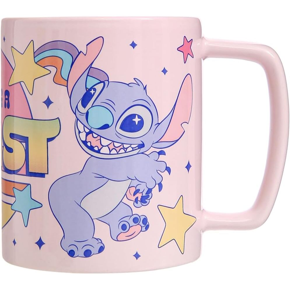 Taza rosa con dibujos animados de Stitch. Estrellas, arcoíris y texto 'Best'. Stitch es azul con orejas grandes y una gran sonrisa.