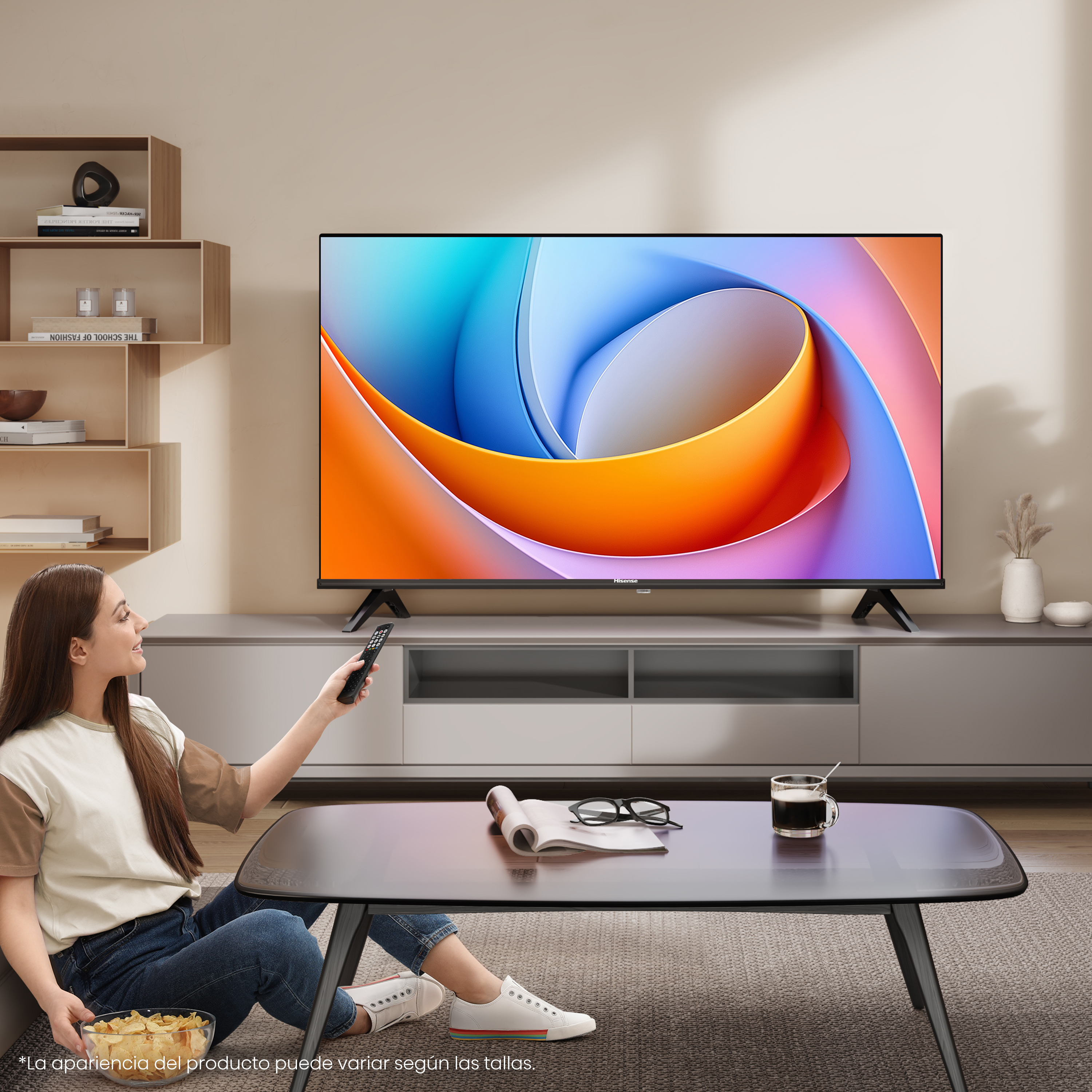 Mujer con mando a distancia viendo la tele. El televisor tiene un diseño abstracto colorido. Patatas fritas y café en la mesa.