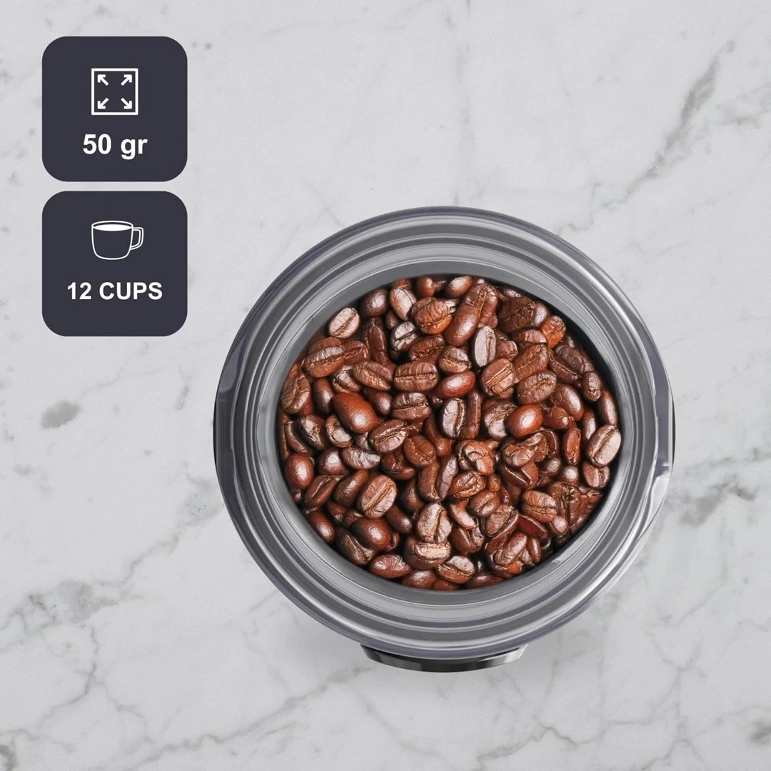 Ziarna kawy w pojemniku. Pokazuje również 50g i 12 filiżanek. Tło to marmurowa powierzchnia.