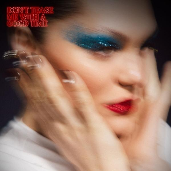 Ein Frauen-Gesicht mit hellblauem Lidschatten und rotem Lippenstift. Ihre Hände sind verschwommen in der Nähe ihres Gesichts. Text: Don't tease me with a good time.