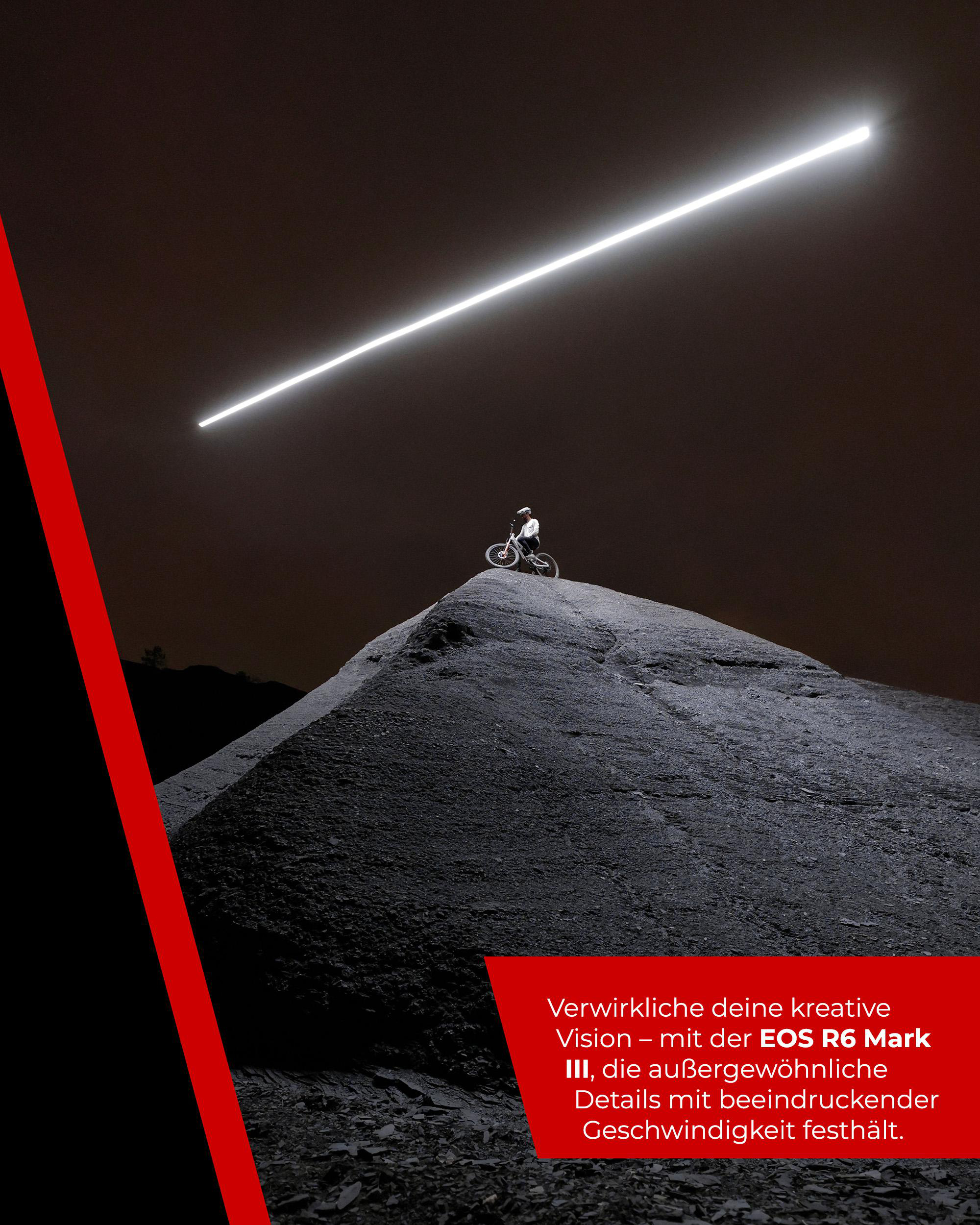 Ein Radfahrer auf einem Berg aus dunklem Material unter einem hellen Licht. Rote und schwarze diagonale Linien links.