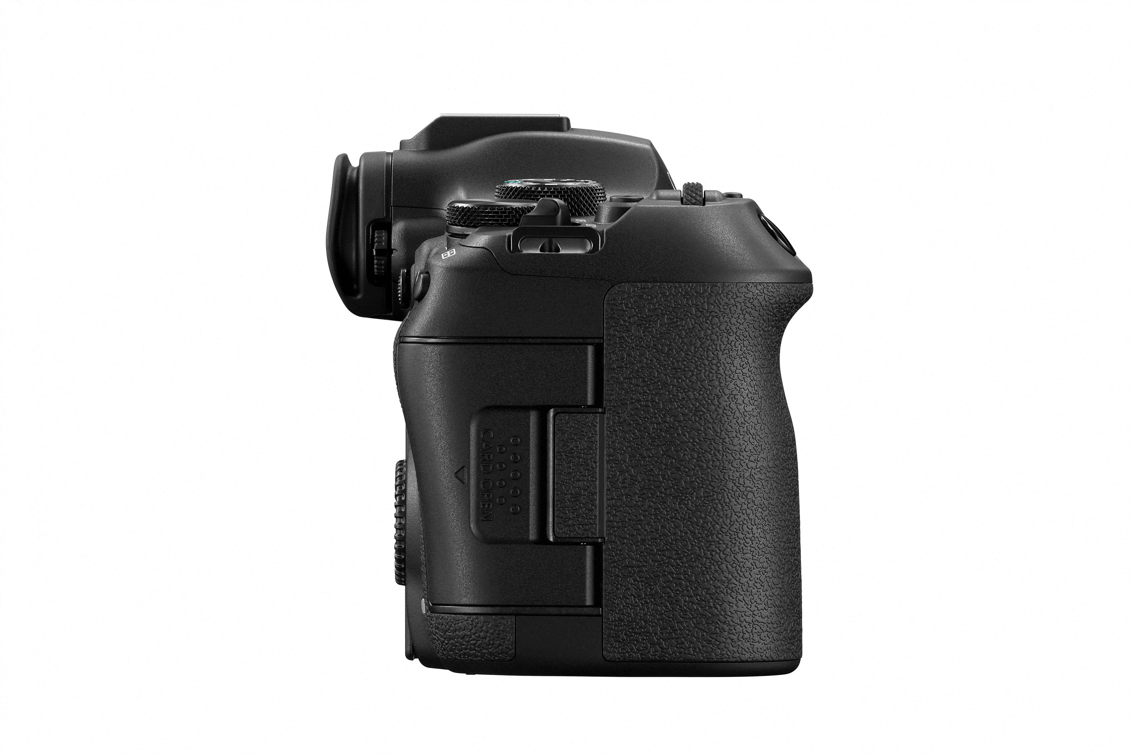 Seitenansicht einer schwarzen Kamera, mit Knöpfen, Einstellrädern, Griff und Kartensteckplatz, vor weißem Hintergrund.