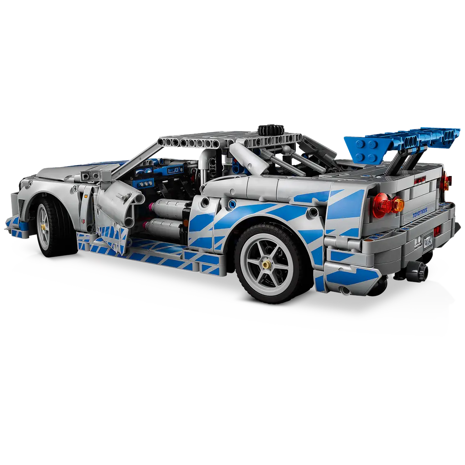 A silver and blue Lego car with a large spoiler is on a white background. The car has open doors and detailed interior visible.