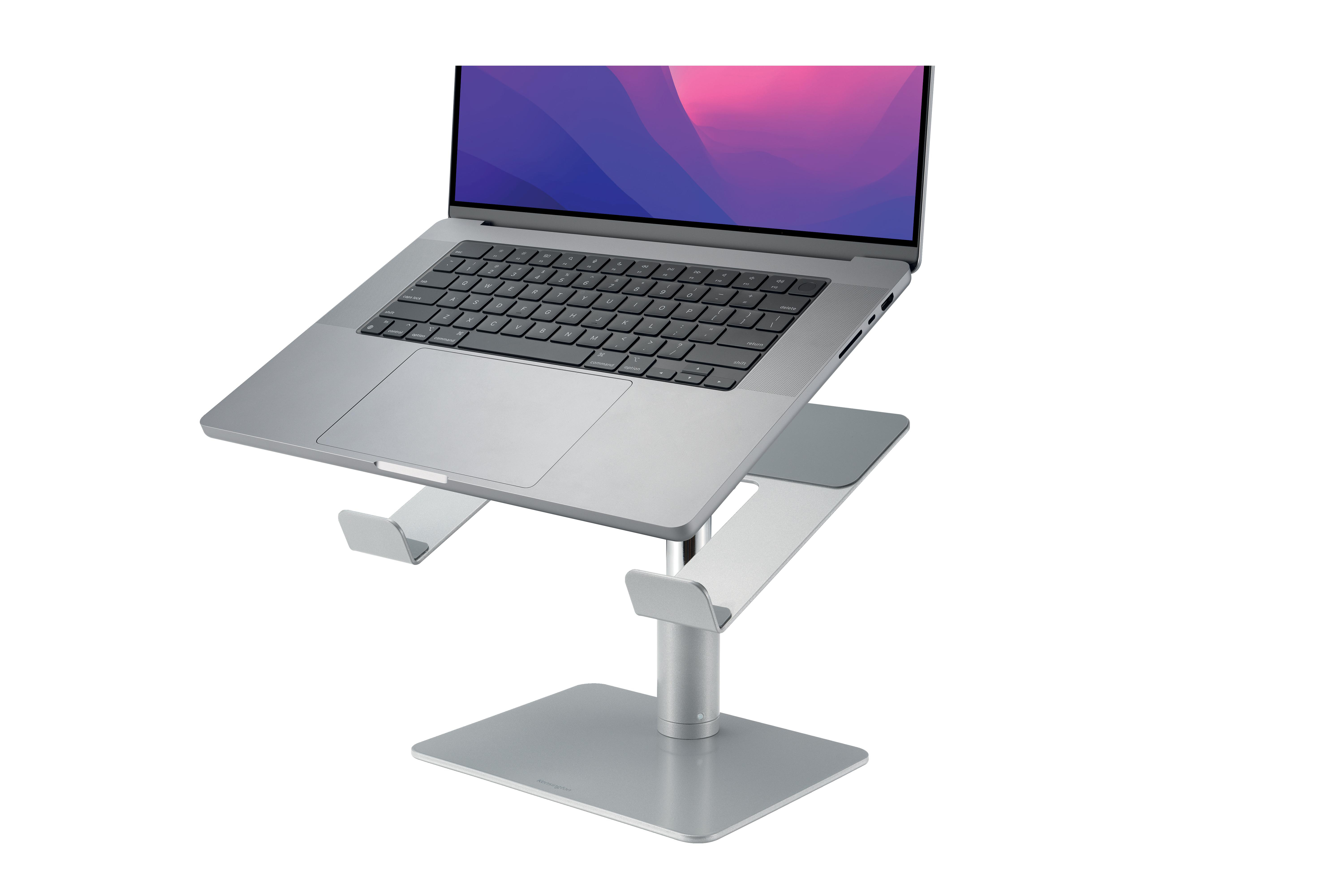 Ein silberner Laptop auf einem silbernen Ständer mit Tastatur. Der Bildschirm zeigt einen rosa-violetten Farbverlauf.