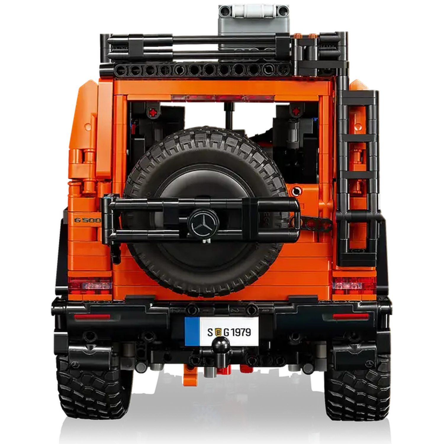 Vue arrière d'un véhicule tout-terrain jouet orange et noir. Il a une roue de secours, une échelle et un porte-bagages.