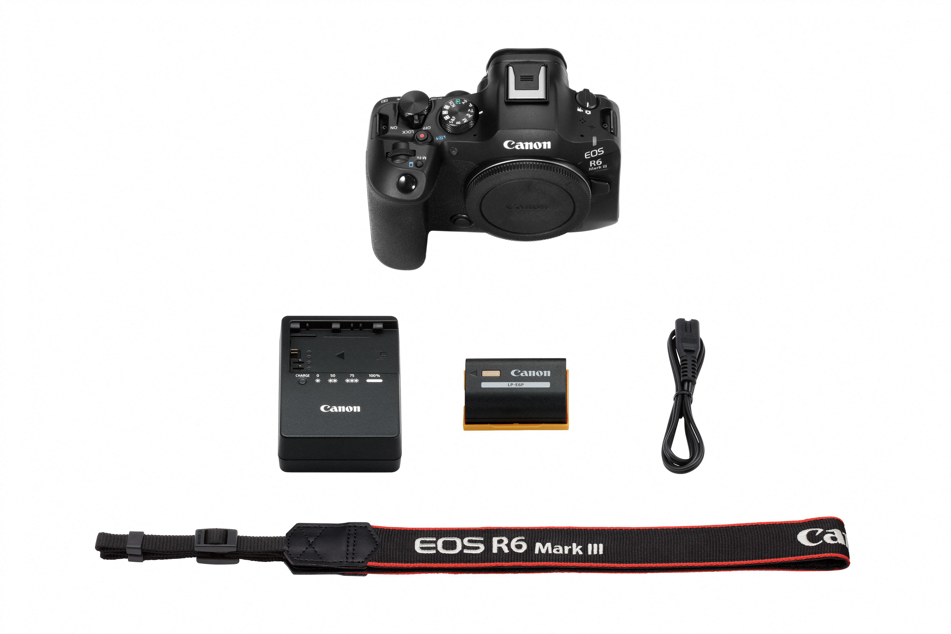 Eine Canon EOS R6 Mark III Kamera und Zubehör liegen auf weißem Untergrund. Enthalten sind Akku, Ladegerät, Gurt und Kabel.