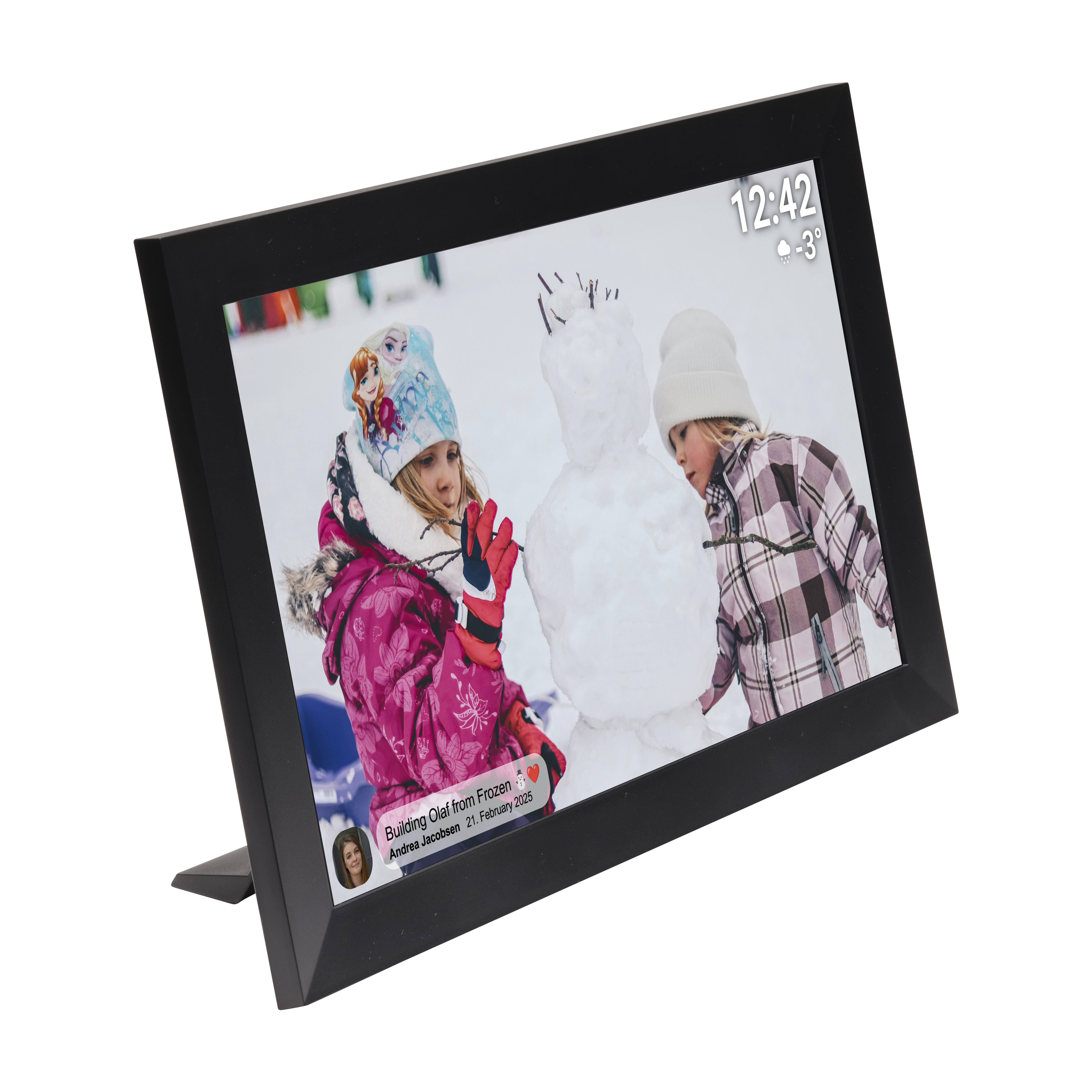 Zwei Mädchen bauen einen Schneemann, dargestellt auf einem digitalen Rahmen. Eines trägt Pink, das andere eine karierte Jacke. Schneeiger Hintergrund.