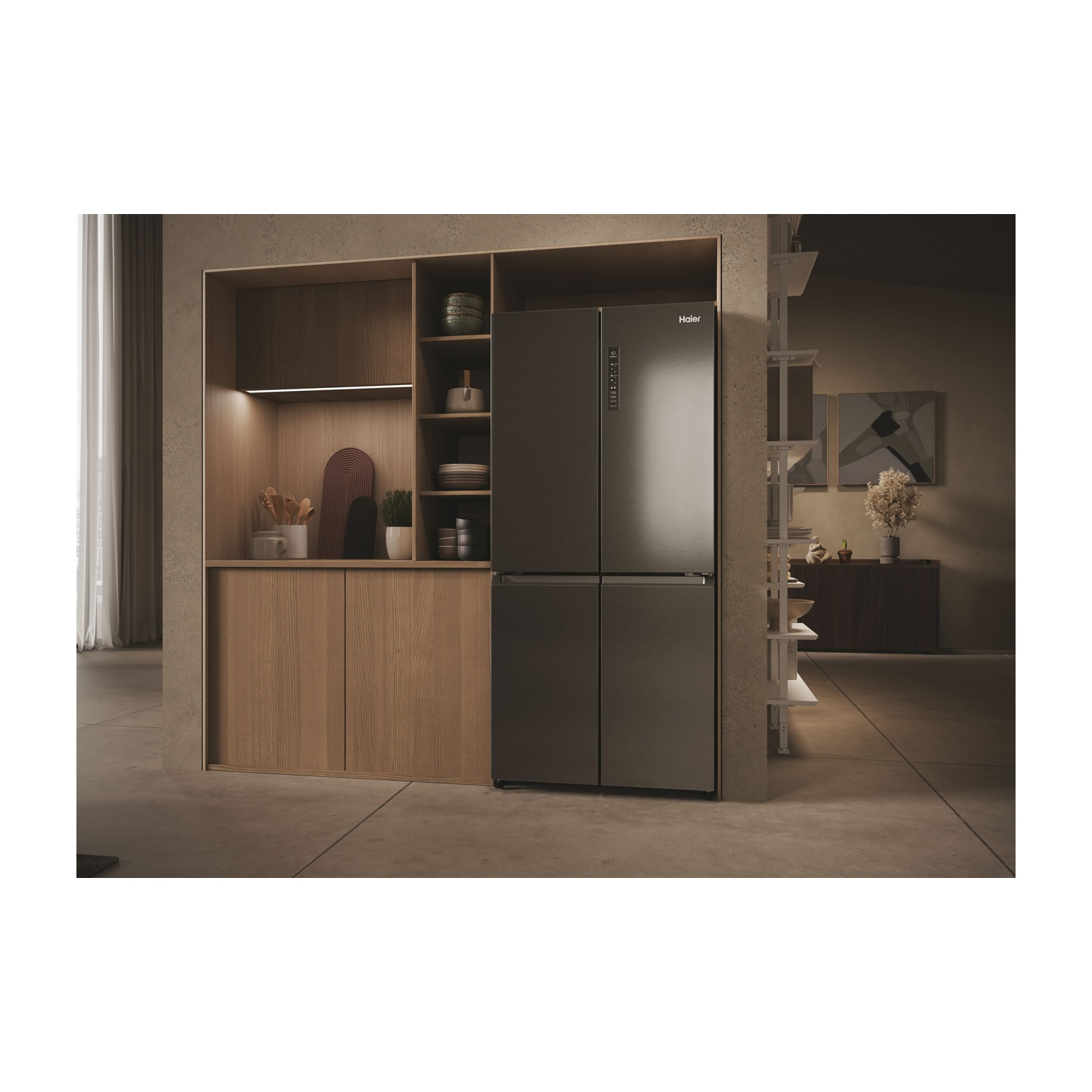 Una cucina moderna con frigorifero Haier. Sono visibili mobili e scaffali in legno. Sugli scaffali ci sono oggetti decorativi. Il pavimento è in cemento.