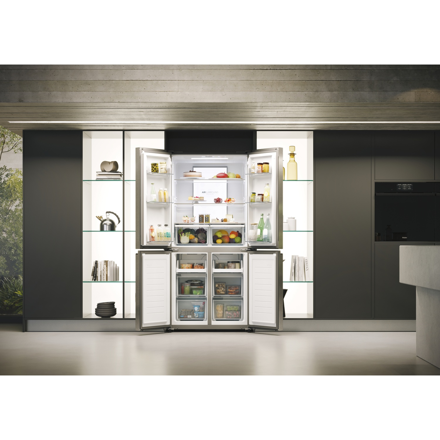 Frigorifero in acciaio inox aperto pieno di cibo. Ambiente cucina con armadi, ripiani in vetro e forno. Design moderno.