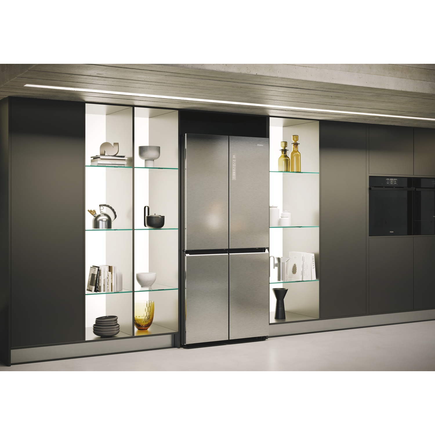 Una cucina moderna con frigorifero in acciaio inox. Armadi su entrambi i lati. Mensole con oggetti decorativi.
