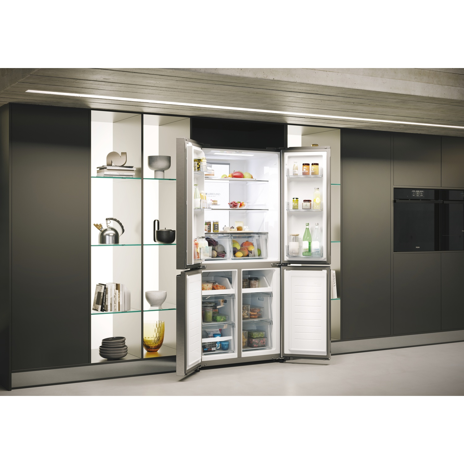 Frigorifero aperto in acciaio inossidabile in una cucina moderna con cibo all'interno, accanto a un mobile con piatti e decorazioni.
