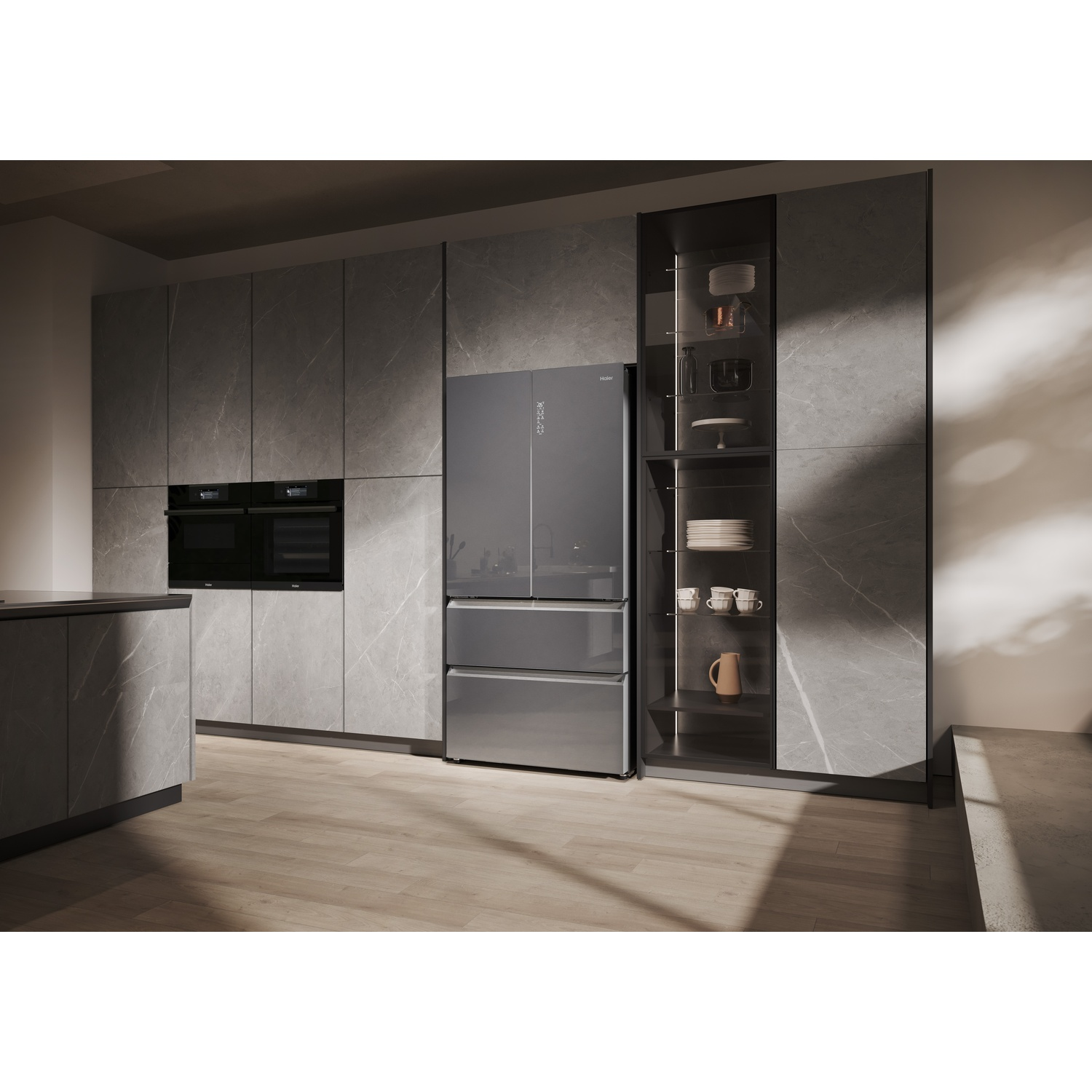 Una cucina moderna con frigorifero grigio, forni a incasso e armadi. Armadietto con porta a vetri a destra. Pavimento in legno.