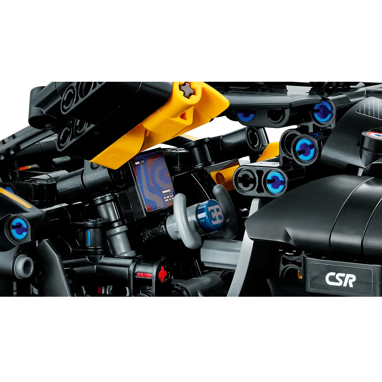 Close-up van een zwart en geel Lego-automodel. Details zijn onder meer blauwe accenten, een kleine kaart en de letters 'CSR'.