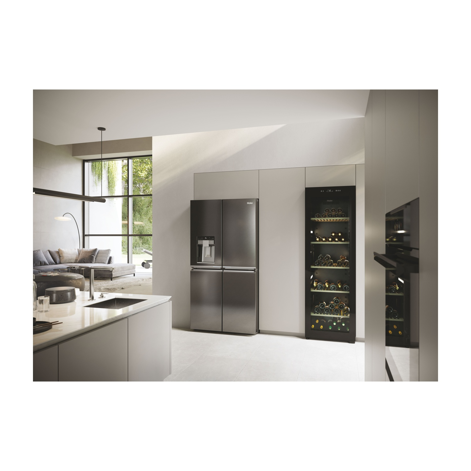 Una cucina moderna con frigorifero in acciaio inox, cantinetta e isola. Un soggiorno con divano è visibile attraverso una finestra.